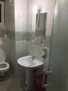 Un baño con lavabo, inodoro y espejo. en Kod Bolnice, en Novi Pazar
