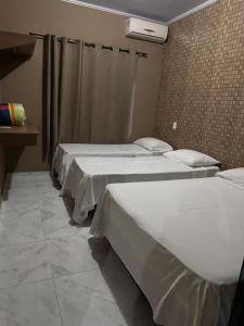 ピレノポリスにあるCasa Raio de Luzの部屋に3つのベッドが並んでいる