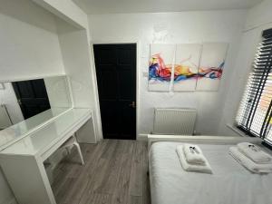 a room with a bed and a desk and a mirror at Modern Pink Cottage in Blackpool in Blackpool +8 photos