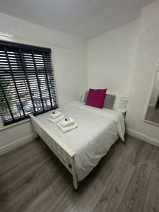 a bedroom with a bed with two towels on it at Modern Pink Cottage in Blackpool in Blackpool