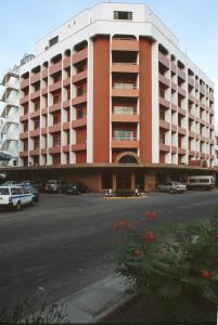 a large building with cars parked in a parking lot at Royal Court Hotel in Mombasa