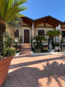 a house with palm trees in front of it at Hotel 2000 in Giugliano in Campania