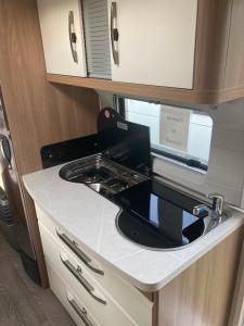 DrebkauWohnwagen am See的配有微波炉和水槽的厨房柜台