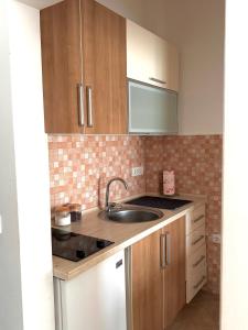 a kitchen with wooden cabinets and a sink at Aria Apartment in Ulcinj +2 photos