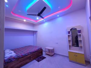 a bedroom with a bed and a ceiling with neon lights at RS Homestay Puri in Puri +24 photos
