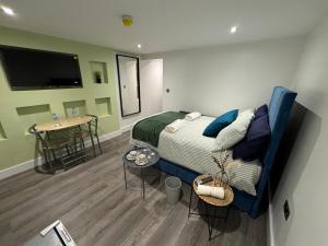 a bedroom with a bed and a table in it at Luxury 6-Bed House - 6 En Suite- Jaquzzi Baths - Private Parking - Sleeps 22- 2 Min M62 in Elland