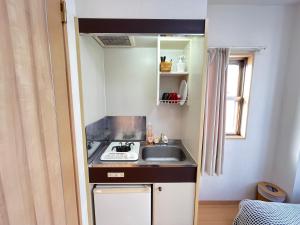 a small kitchen with a sink and a stove at シャンテ高田馬場41 in Tokyo