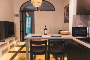 a kitchen with a table with two glasses of wine at NORMALT- luxurious stay in Il-Furjana +5 photos