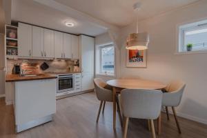 een keuken met een tafel en stoelen in een keuken bij Apartment in Tromsø City Centre in Tromsø