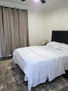 a bedroom with a white bed and a window at Renovated 2 Bed Walltown Home Walk To Duke! B in Durham