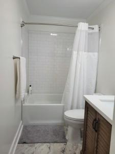 a bathroom with a tub and a toilet and a sink at Renovated 2 Bed Walltown Home Walk To Duke! B in Durham +10 photos