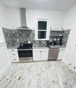 a kitchen with white cabinets and black and white wallpaper at Renovated 1 Bedroom In Forest Hills - B in Durham