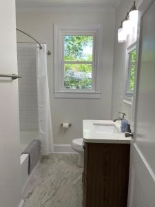a bathroom with a sink and a toilet and a window at Renovated 1 Bedroom In Forest Hills - B in Durham +9 photos