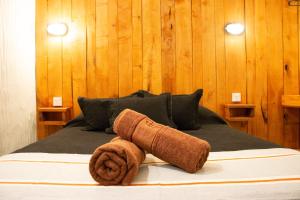 a bed with two towels on top of it at EcoHotelTDF in Río Grande