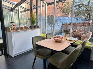 uma sala de jantar com mesa e cadeiras numa estufa em B&B Contrast em Bruges
