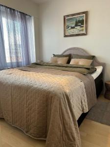 a large bed in a bedroom with a window at Fredrik Kaksio Haminassa in Hamina