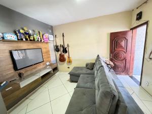 a living room with a couch and a flat screen tv at SOBRADO COM 3 QUARToS in Barretos