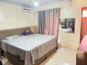 a bedroom with a bed and a mirror at SOBRADO COM 3 QUARToS in Barretos