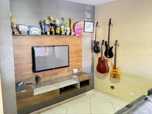 a living room with guitars hanging on the wall at SOBRADO COM 3 QUARToS in Barretos