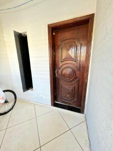 a wooden door in a room with a tile floor at SOBRADO COM 3 QUARToS in Barretos +4 photos