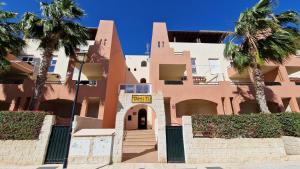 a building with palm trees in front of it at Apartamento junto al mar in Vera +38 photos