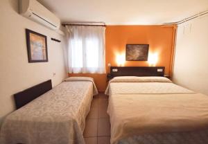 A bed or beds in a room at Hotel Alegret