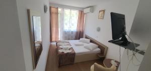 a small room with a bed and a window at Hotel Pescarus in Mamaia