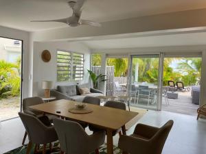 a living room with a wooden table and chairs at Palm Beach House, Stunning 2 bedrooms beachfront, Nettle Bay Beach Club in Baie Nettle