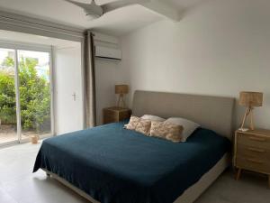 a bedroom with a blue bed and a window at Palm Beach House, Stunning 2 bedrooms beachfront, Nettle Bay Beach Club in Baie Nettle
