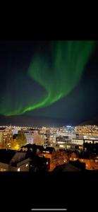 een beeld van een stad met het noorderlicht in de lucht bij Apartment in Tromsø City Centre in Tromsø