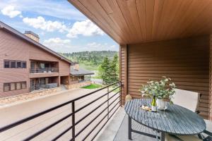 einen Balkon mit einem Tisch mit Blumen darauf in der Unterkunft 1BR Deer Valley Condo-On FREE Shuttle Line in Park City