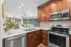 eine Küche mit Holzschränken und Geräten aus Edelstahl in der Unterkunft 1BR Deer Valley Condo-On FREE Shuttle Line in Park City