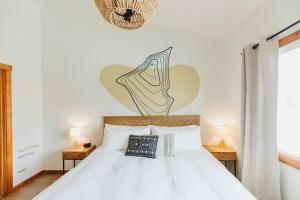 een slaapkamer met een wit bed en 2 nachtkastjes bij Mt Cleveland at Switchback Suites in Kalispell