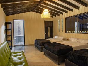 un dormitorio con dos camas y un sofá en Hermosa finca con vista a la piedra y embalse de Guatapé, con jacuzzi y piscina, en Guatapé 22 fotos más