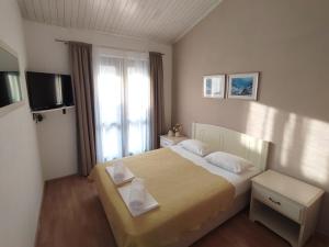 a hotel room with a bed and a television at Villa Tilda in Brela +8 photos