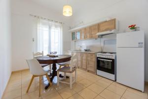 a kitchen with a table and a white refrigerator at Spacious seaview apartment in Heraklion in Heraklio