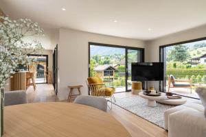 un soggiorno con un tavolo e una tv di La Villa 225 - Lac Annecy a Saint-Jorioz