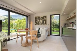 una cucina e un soggiorno con un tavolo e un divano di La Villa 225 - Lac Annecy a Saint-Jorioz