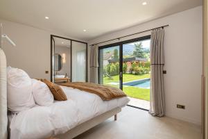 una camera da letto con un letto e una grande finestra di La Villa 225 - Lac Annecy a Saint-Jorioz Altre 30 foto