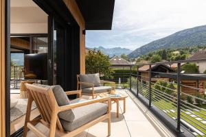 un balcone con due sedie e un tavolo di La Villa 225 - Lac Annecy a Saint-Jorioz