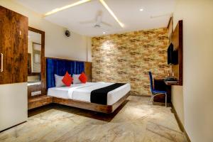 a bedroom with a bed and a desk in a room at Capital O Abri Krishna in Indore