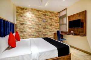 a hotel room with a bed and a tv at Capital O Abri Krishna in Indore