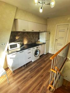 una cocina con estufa y microondas en Lovely Apartment in Chisinau, en Chişinău 4 fotos más