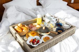 a tray of breakfast food on a bed at Villa Boréal Hostellerie Pousada Boutique in Águas de Lindoia