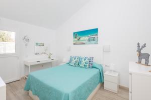 ein weißes Schlafzimmer mit einem Bett und einem Schreibtisch in der Unterkunft Playa del Aguila Bungalow con Terraza Solarium in Maspalomas
