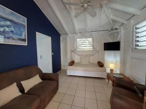 a living room with a couch and a ceiling fan at Love Lodge Guadeloupe - Love Room Romantique Saint Francois in Saint-François