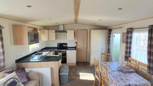 eine Küche und ein Wohnzimmer mit Tisch und ein Esszimmer in der Unterkunft Luke's Hideaway at Seal Bay Resort in Selsey
