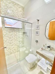 a bathroom with a shower and a toilet and a sink at Casa do Lago da Dinda 2 in Espirito Santo Do Pinhal +18 photos