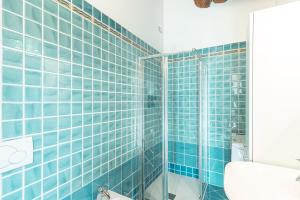 baño de azulejos azules con ducha de cristal en Mansarda Magellano - Parcheggio Auto, en Ferrara 27 fotos más
