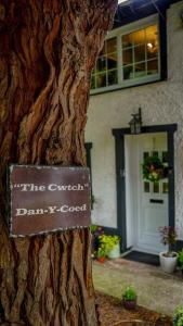 a sign on a tree in front of a house at Country Cottage Annex (The Cwtch) in Gilwern